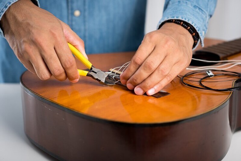 Gắn dây và tune dây đàn guitar để hoàn tất bước vệ sinh đàn guitar