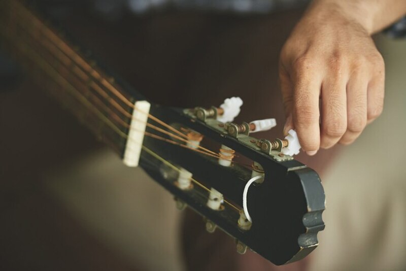 Bạn thực hiện gỡ dây đàn guitar để vệ sinh đàn nhanh và tránh nước rửa, vải lau dính vào dây đàn
